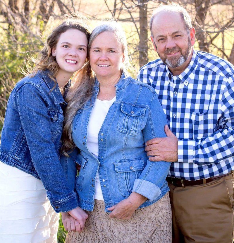 A family posing for a picture in the woods.